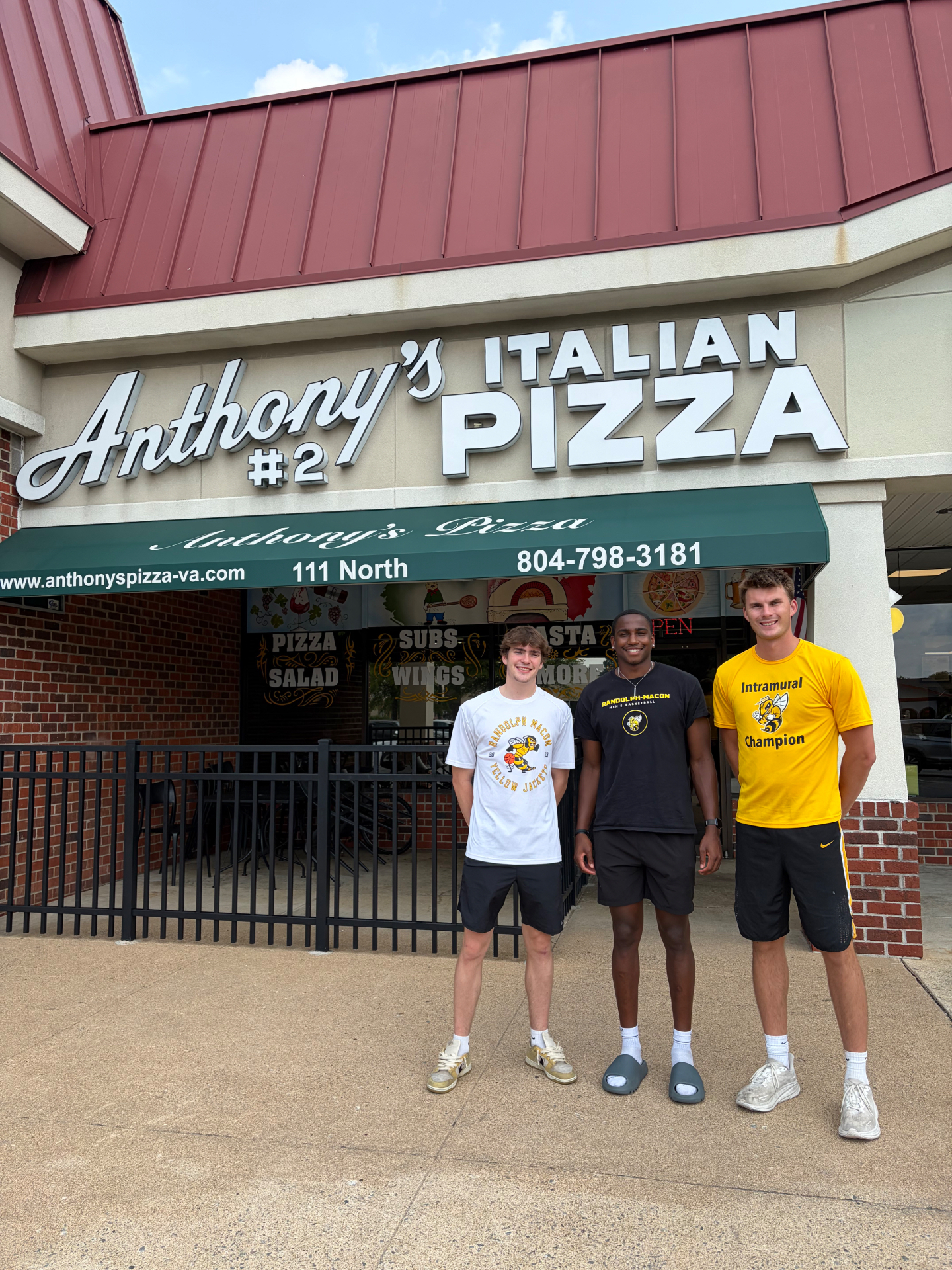 Three Randolph–Macon men's basketball student-athletes outside Anthony's Italian Pizza in Ashland, Virginia