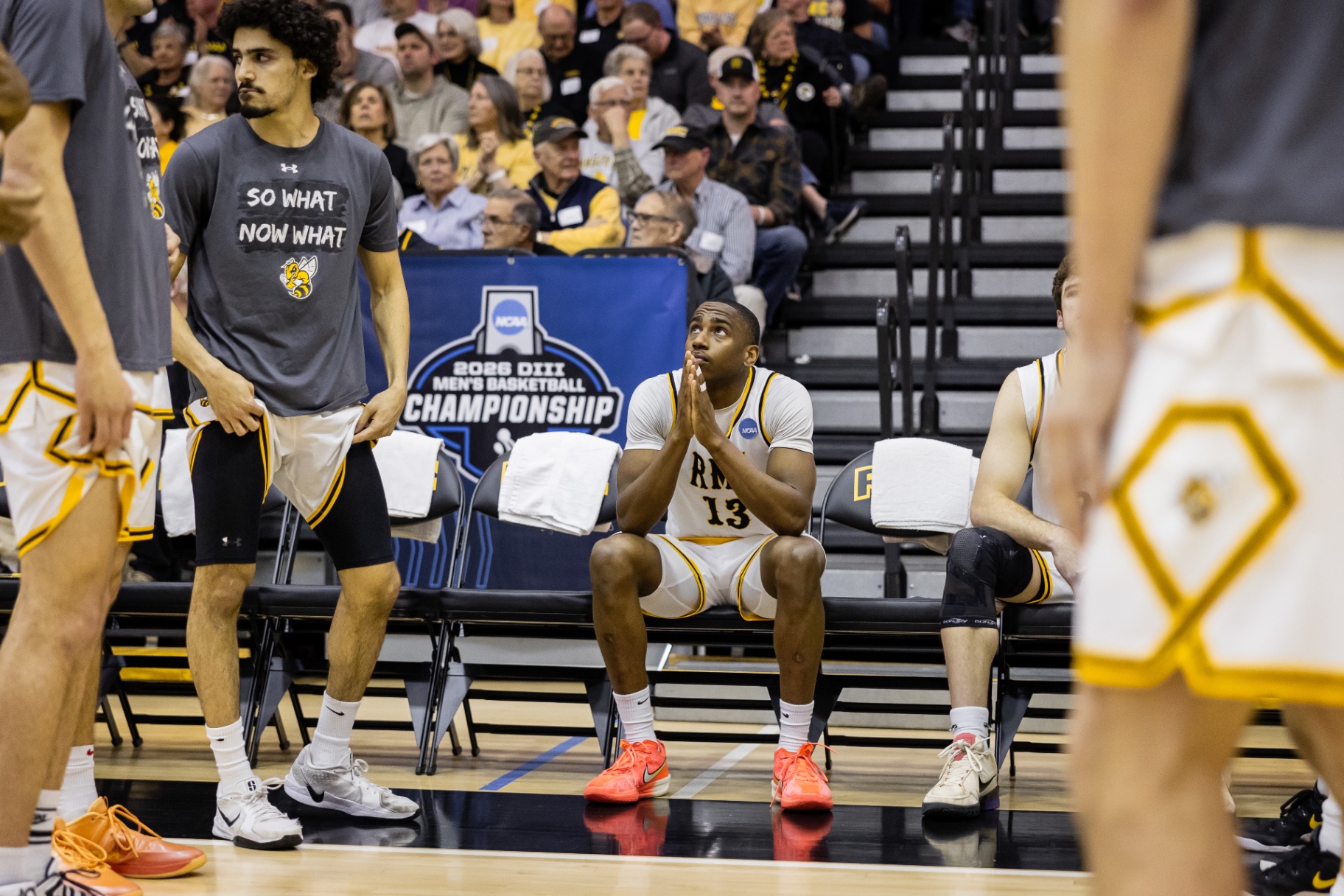 Randolph–Macon #13 seated on the bench, focused, during the NCAA Sweet 16