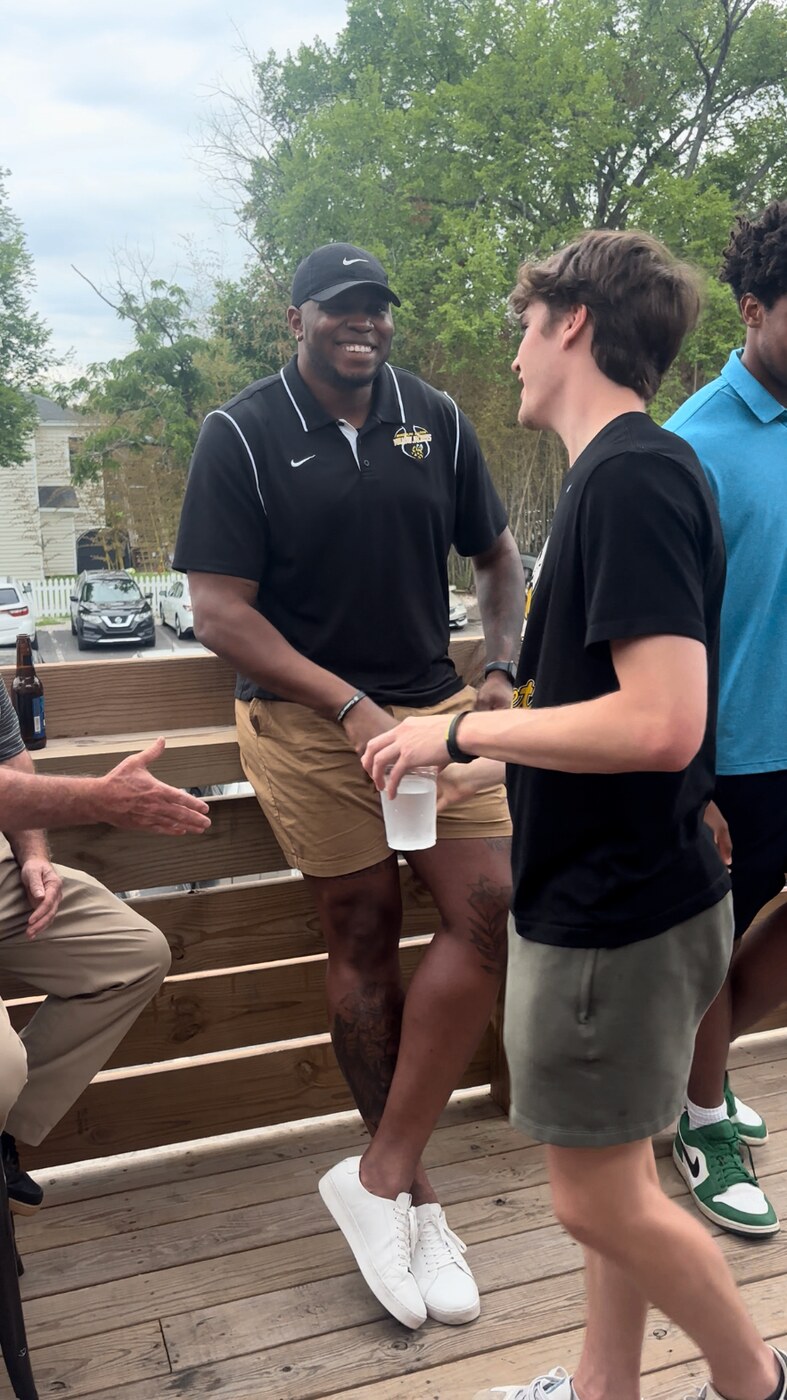 Alumnus shaking hands with a Randolph–Macon student-athlete